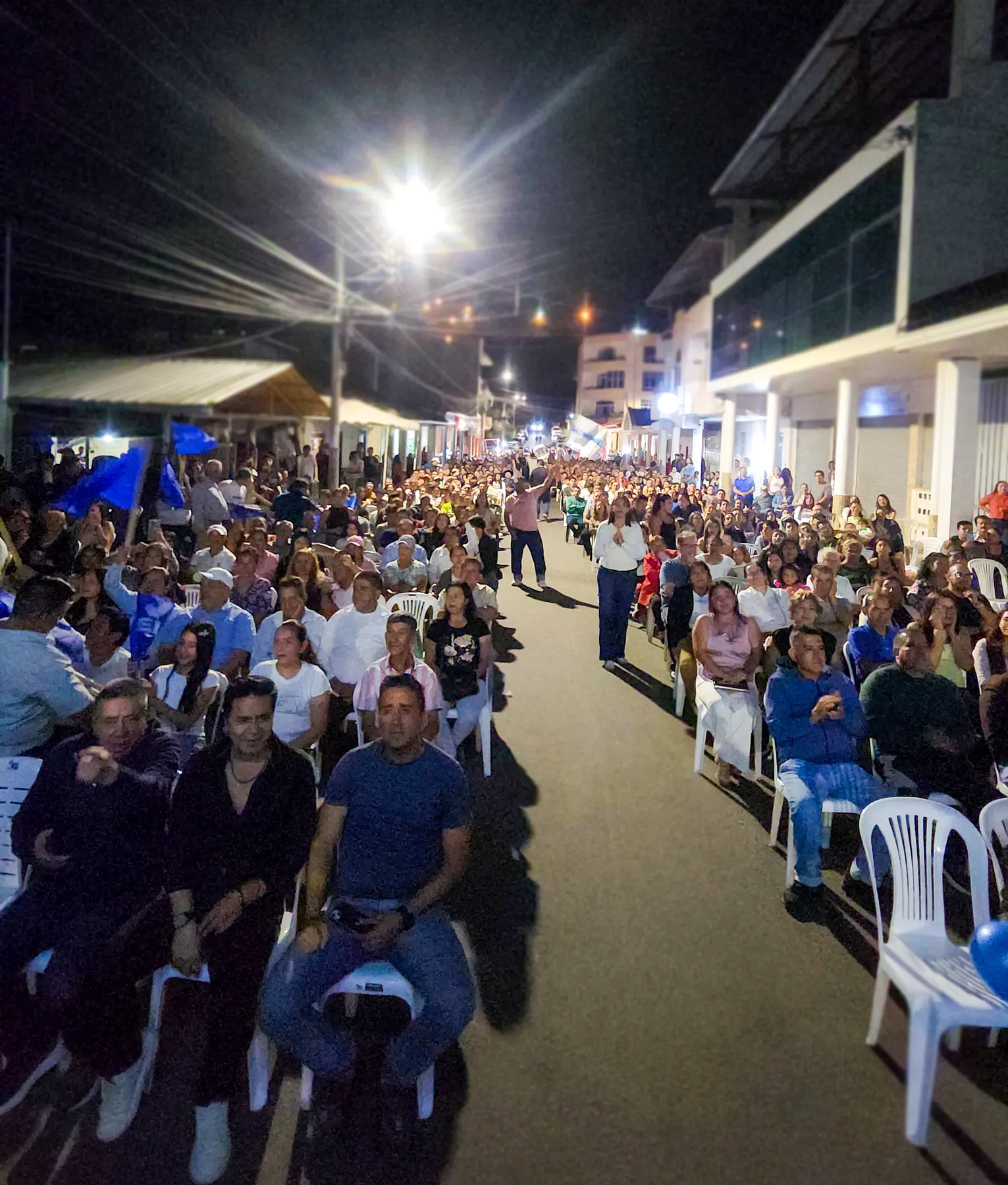 Gran cantidad de asistentes ocupando una calle durante un acto nocturno