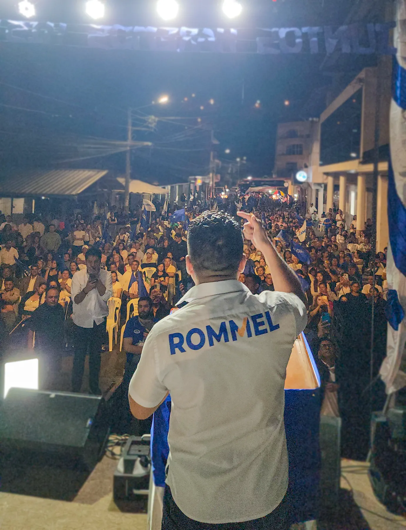Rommel Durán de espaldas dialogando con una multitud reunida de noche